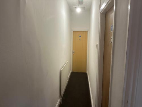 a hallway with a stairway with a yellow door at Cosy 4 Bedroom Walsall House - Free WiFi & Parking in Bescot
