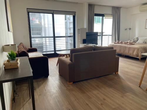 a living room with a couch and a bed at Loft Full Amenities en Retiro in Buenos Aires