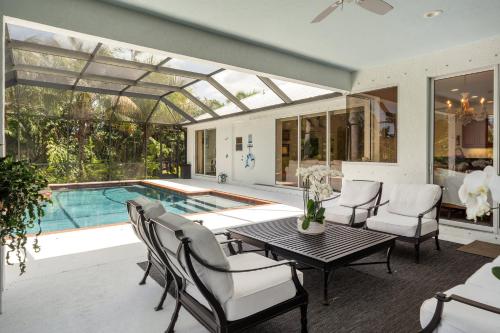 a conservatory with a table and chairs next to a pool at Tranquil Court Oasis in Sarasota