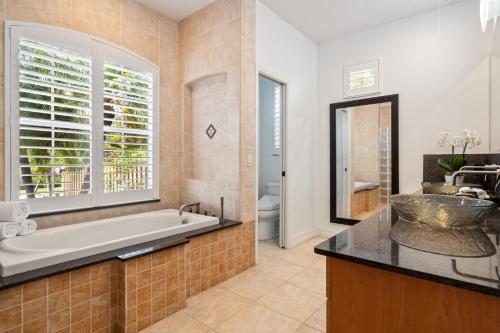 a bathroom with a tub and a sink and a window at Tranquil Court Oasis in Sarasota