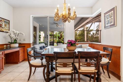 a dining room with a table and chairs and a chandelier at Tranquil Court Oasis in Sarasota