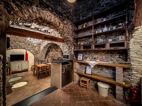 a kitchen with a stone wall with a stove at The Historic Oil Mill- Romantic Retreat in Alassio