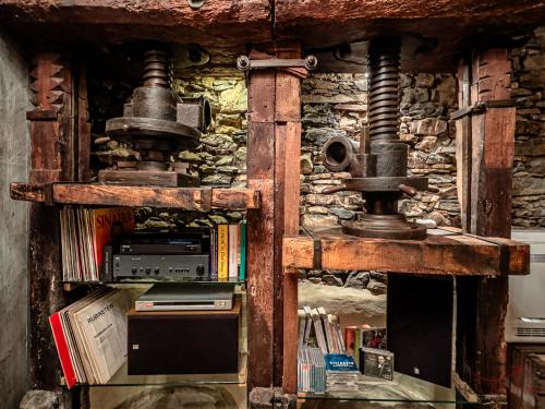 a book shelf with an old fashioned machine at The Historic Oil Mill- Romantic Retreat in Alassio