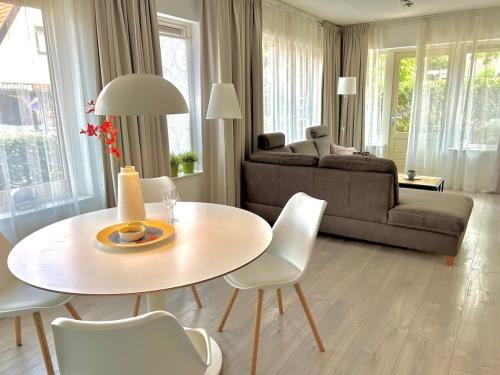 a living room with a table and a couch at Luxe Duinsuite in Groet