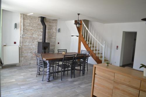 une salle à manger avec une table et des chaises et un escalier dans l'établissement Maison 3 chambres , terrasse et garage à 20 min de La Rochelle, à Nuaillé-dʼAunis