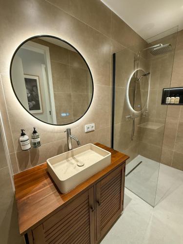 a bathroom with a sink and a shower with a mirror at B&B De Amsterdamse Poort in Haarlem