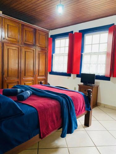 a bedroom with a bed with red and blue at Cantinho Pilar in Ouro Preto