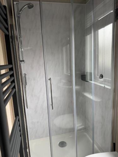 a shower with a glass door in a bathroom at Bliss on the Bay at Waterside Holiday Park in Paignton