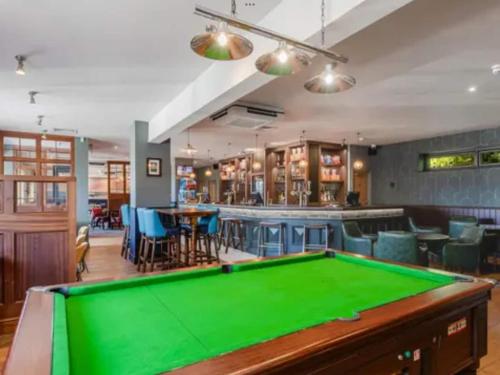 a pool table in a room with a bar at Bliss on the Bay at Waterside Holiday Park in Paignton