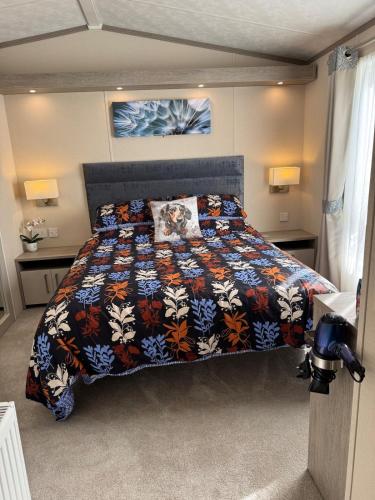 a bedroom with a bed with a colorful comforter at Bliss on the Bay at Waterside Holiday Park in Paignton