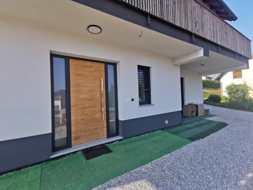 a front door of a house with a green lawn at Apartma Lipa in Veliki Gaber