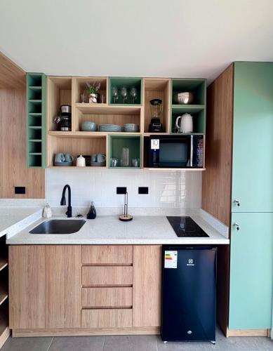 a kitchen with a sink and a refrigerator at Tiny House con Piscina Privada, AC and Starlink in Paracas