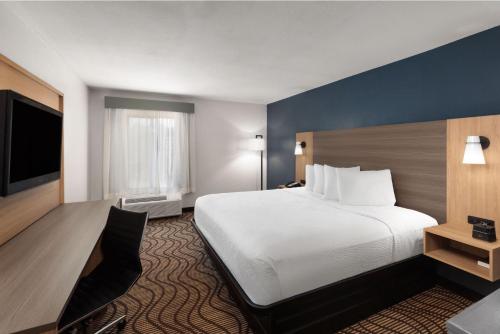 a hotel room with a bed and a flat screen tv at Baymont by Wyndham Moss Point in Moss Point