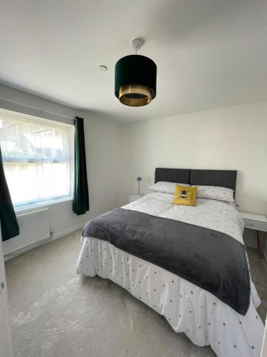 a bedroom with a bed with a yellow pillow on it at Quiet and Central, Modern Bungalow in Hereford