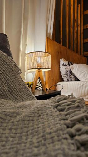 a bedroom with a bed and a lamp on a table at The River in Jinja