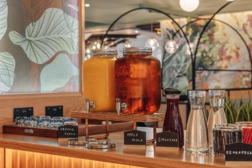 a shelf with two jars of honey and glasses on it at Hotel Indigo London Clerkenwell by IHG in London