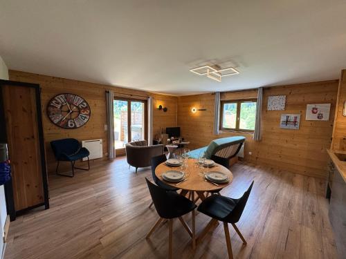 un salon avec une table et des chaises dans l'établissement NEUF chalet 2p Le Suet JACUZZI privatif, à Entremont