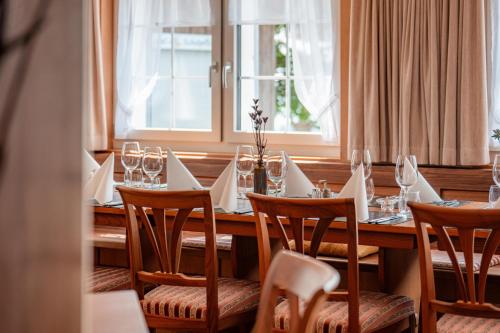 a dining room with a table with chairs and wine glasses at Gasthaus Oberer Gäbris in Gais
