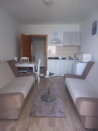 a living room with two couches and a table at Studio apartman Eden sea view in Njivice