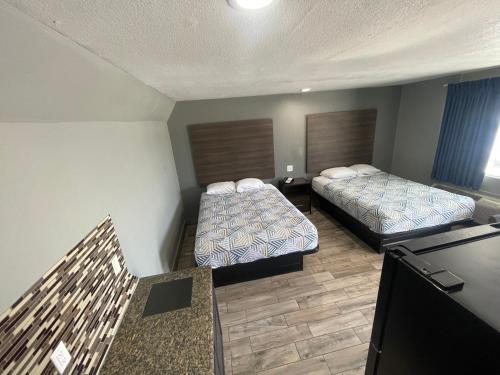 a hotel room with two beds and a television at Gateway Motor Inn in Tulsa