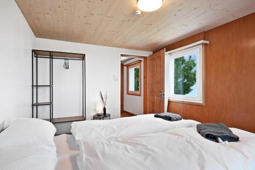 two beds in a bedroom with wooden walls and a window at Gasthaus Oberer Gäbris in Gais