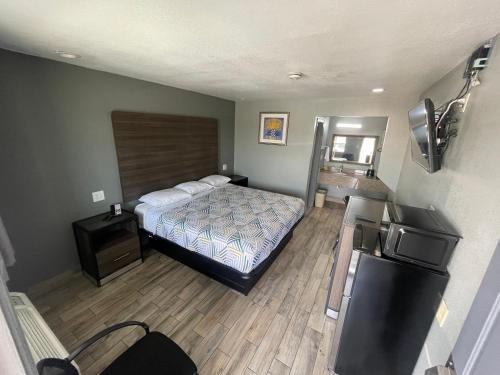 a hotel room with a bed and a refrigerator at Gateway Motor Inn in Tulsa