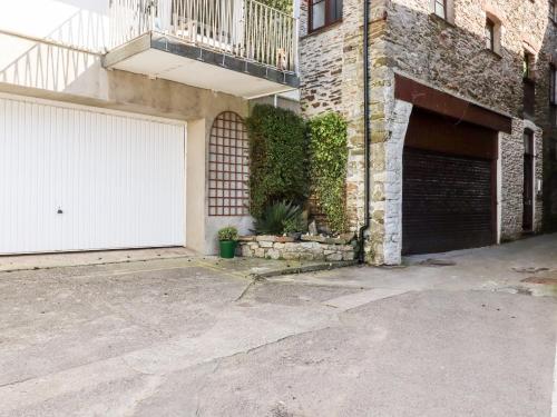 a garage with a white garage door and a building at Smugglers Loft in Looe