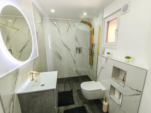 a white bathroom with a sink and a toilet at The Crown Panorama in Jajce