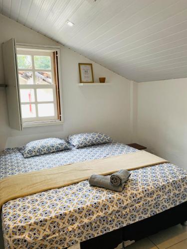 ein Schlafzimmer mit einem Bett in einem Zimmer mit einem Fenster in der Unterkunft Cantinho Familia in Ouro Preto