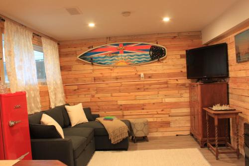 a living room with a couch and a flat screen tv at Rustic Guest Suite in Ucluelet