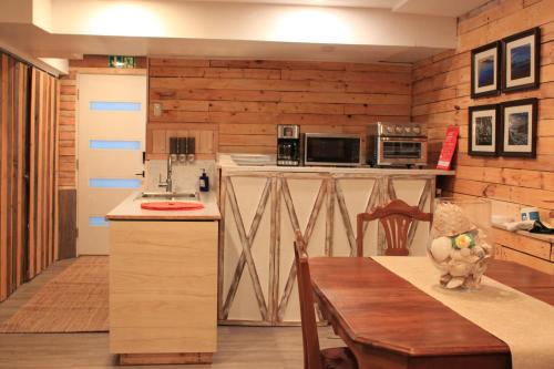 a kitchen with wooden walls and a table with a dining room at Rustic Guest Suite in Ucluelet