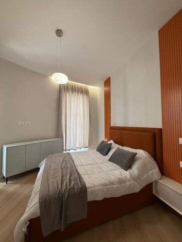 a bedroom with a large bed and a window at Modern City Centre Apartment in Durrës