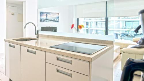 Una cocina con fregadero y una sala de estar. en Las Olas - Luxury apartment in Palm-Mar, en Palm-mar