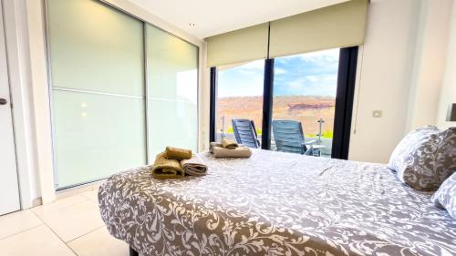 Un dormitorio con una cama y una ventana grande en Las Olas - Luxury apartment in Palm-Mar, en Palm-mar