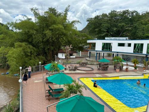 a resort with a swimming pool and a building at Hotel Cascada Cristalina in Melgar