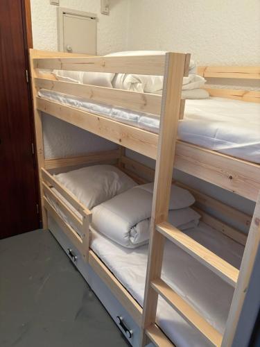 - un lit superposé en bois avec des oreillers dans l'établissement Le studio des oursons, à Auris