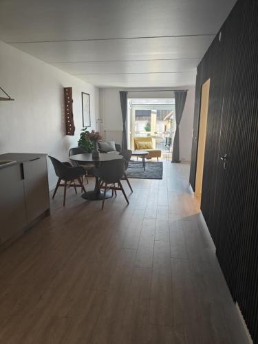 a living room with a table and a dining room at Modern Apartment With Pool & Fitness in Hejls
