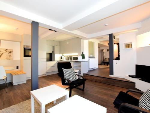 uma sala de estar com mobiliário branco e uma cozinha em Modern and comfortably furnished apartment em Robertville
