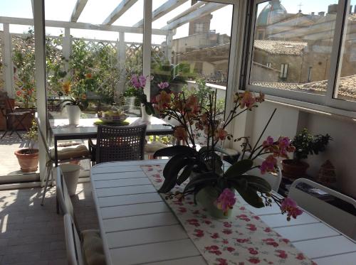 a conservatory with a table with flowers on it at Attico Da Rosa con vista spettacolare a 360 gradi in Caltagirone