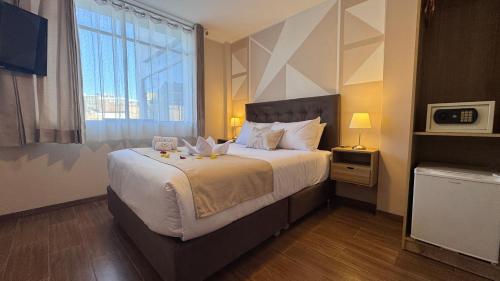 a bedroom with a large bed with a large window at Andari Hoteles in Arequipa