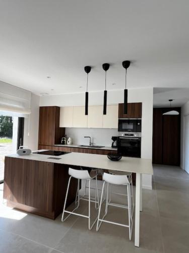 a kitchen with a large island with bar stools at Ty Rosc'OFF, Plain-pied de charme, tout récent, à proximité immédiate du centre de Roscoff in Roscoff