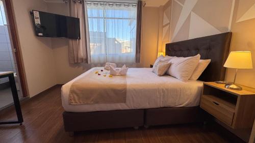 a hotel room with a bed with a television on the wall at Andari Hoteles in Arequipa