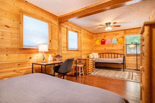 een slaapkamer met houten wanden, een bed en een bureau bij Haus Edelweiss By Avada Properties in Sevierville
