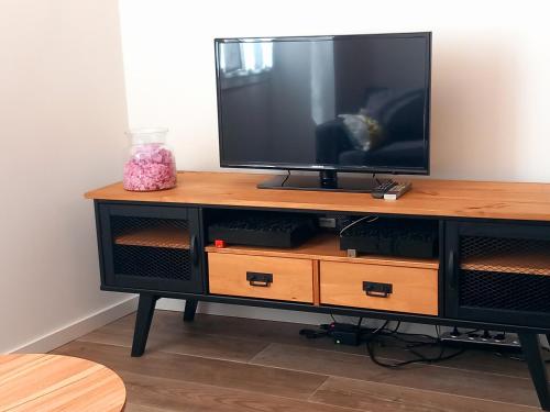 a television sitting on top of a wooden entertainment center at T3 Meublé 6 Couchages in Monein