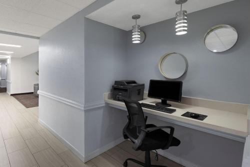 an office with a desk with a computer and a chair at Baymont by Wyndham Moss Point in Moss Point