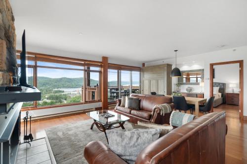 un soggiorno con mobili in pelle e una grande finestra di Play and Explore - Altitude 172-8 a Mont-Tremblant