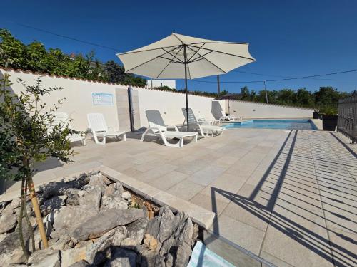 eine Terrasse mit Stühlen und einem Sonnenschirm neben einem Pool in der Unterkunft Villa Draga Crikvenica in Crikvenica