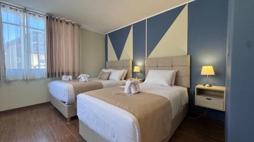 two beds in a hotel room with towels on them at Andari Hoteles in Arequipa