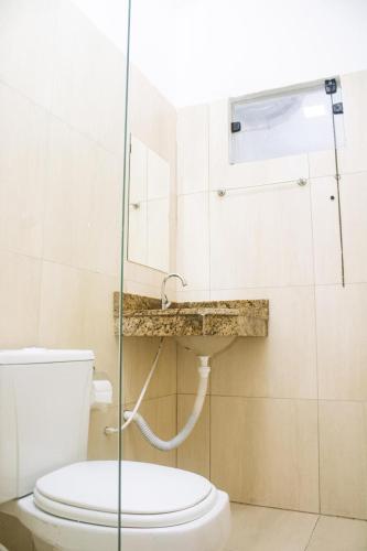 a bathroom with a toilet and a sink at Pousada Salomão in Teixeira de Freitas