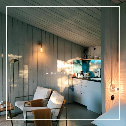 a living room with a table and a kitchen at La Pause En Soi in Ponlat-Taillebourg